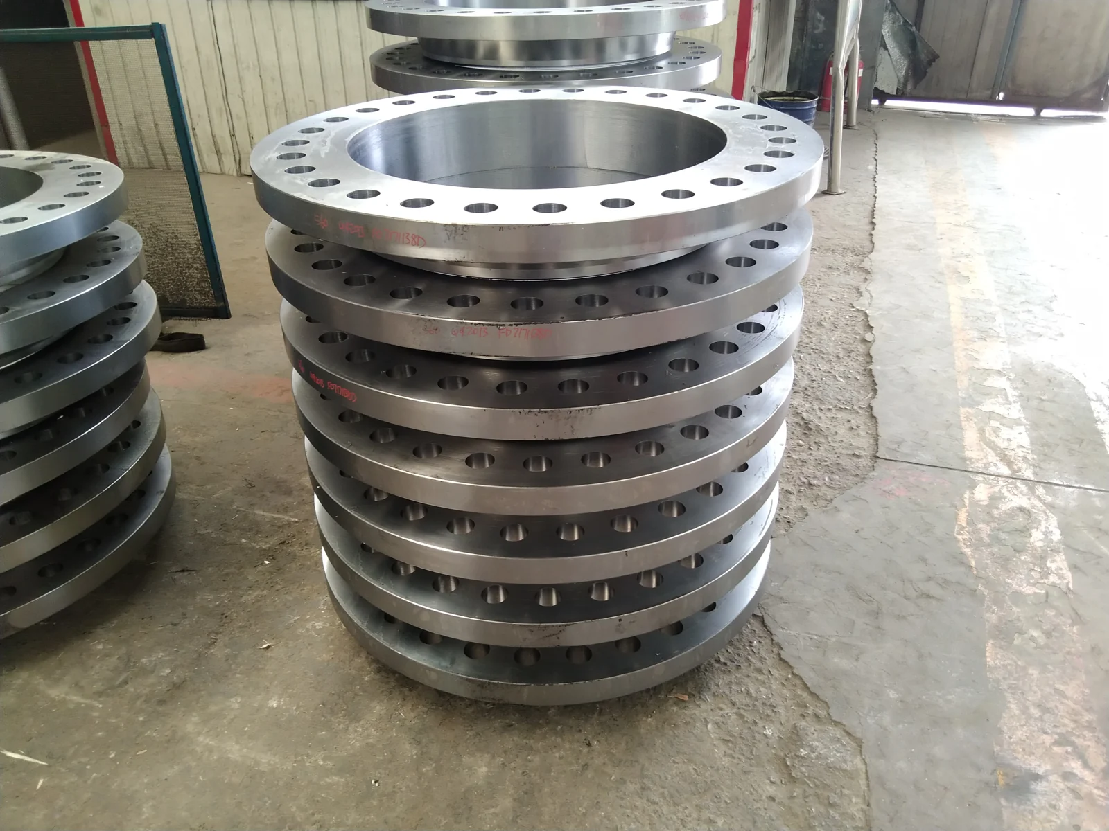 Large-diameter machined flanges stacked in a workshop